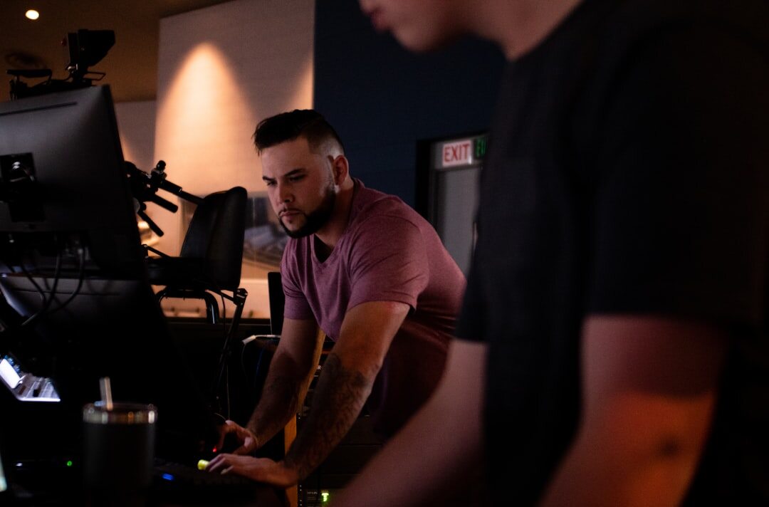 Media professional working on video production software at a multi-monitor broadcast desk